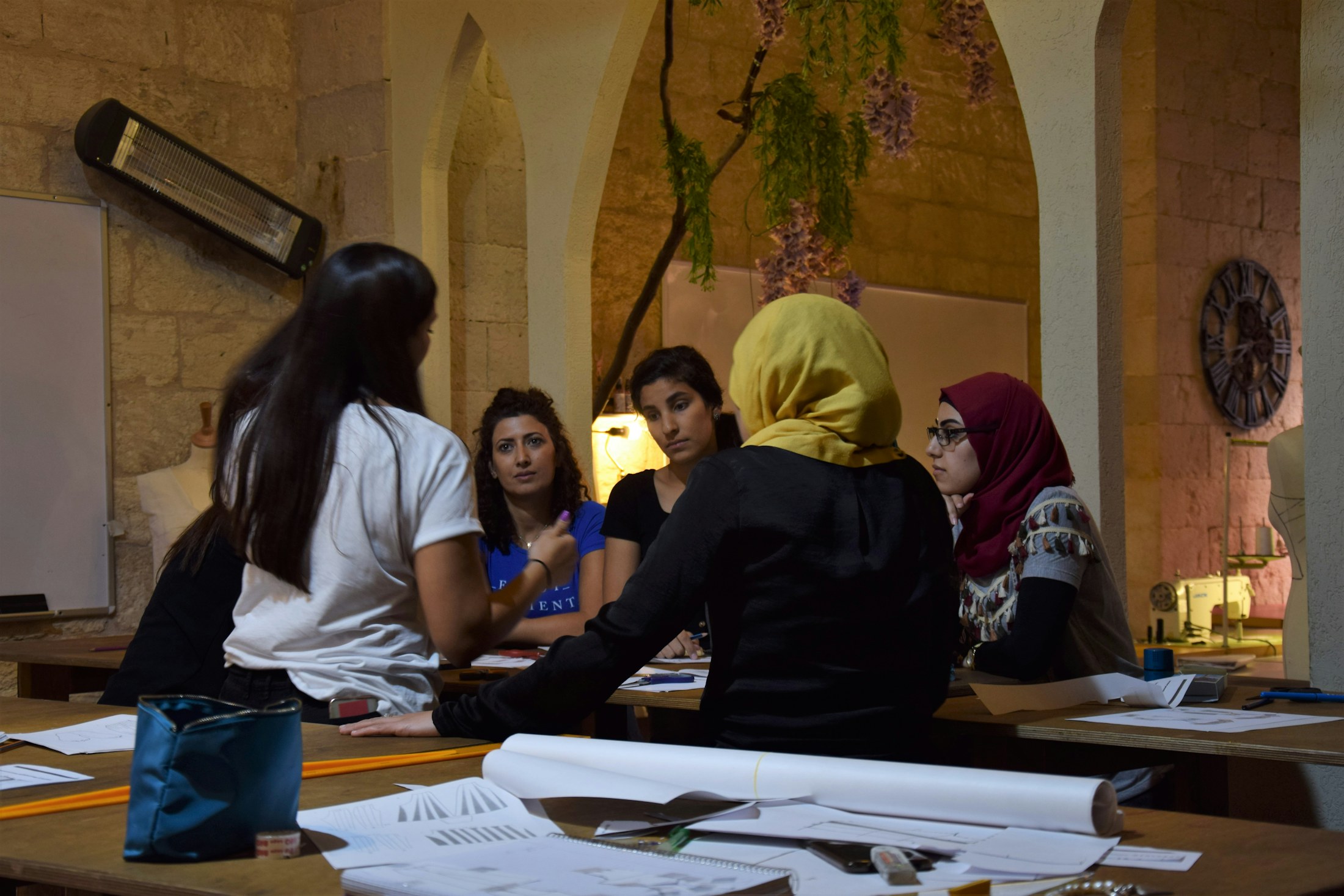 A team examining prototype materials around a work table